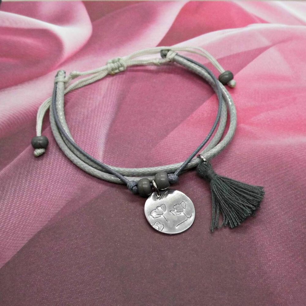graues-armband-mit-anhaenger-und-quaste Armband silber-grau geprägter Anhänger