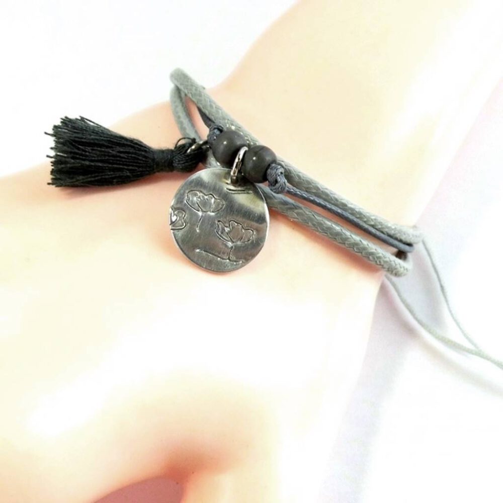 tragebeispiel-armband-gewachste-baumwolle-grau-silber Armband silber-grau geprägter Anhänger