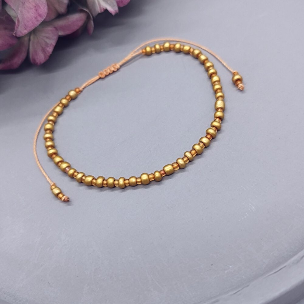 handgefertigtes-armband-gold-orange-rocailles-nylonfaden Armband gold-orangene Rocailles