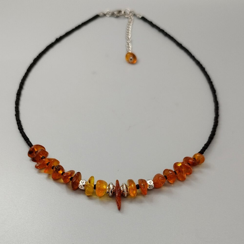Choker-Kette auf einem neutralen Hintergrund. Zeitlose Eleganz Die Choker-Kette ist ein Must-have für jeden Schmuckkästchen. Bernstein Kette schwarz-silber
