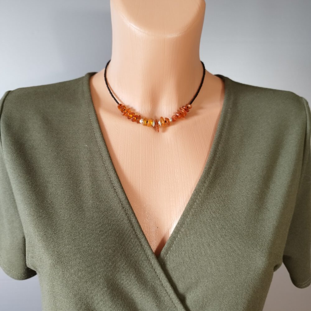 Choker-Kette um ein Model gelegt. Einzigartiges Statement Die Choker-Kette setzt deinen Hals wunderschön in Szene. Bernstein Kette schwarz-silber