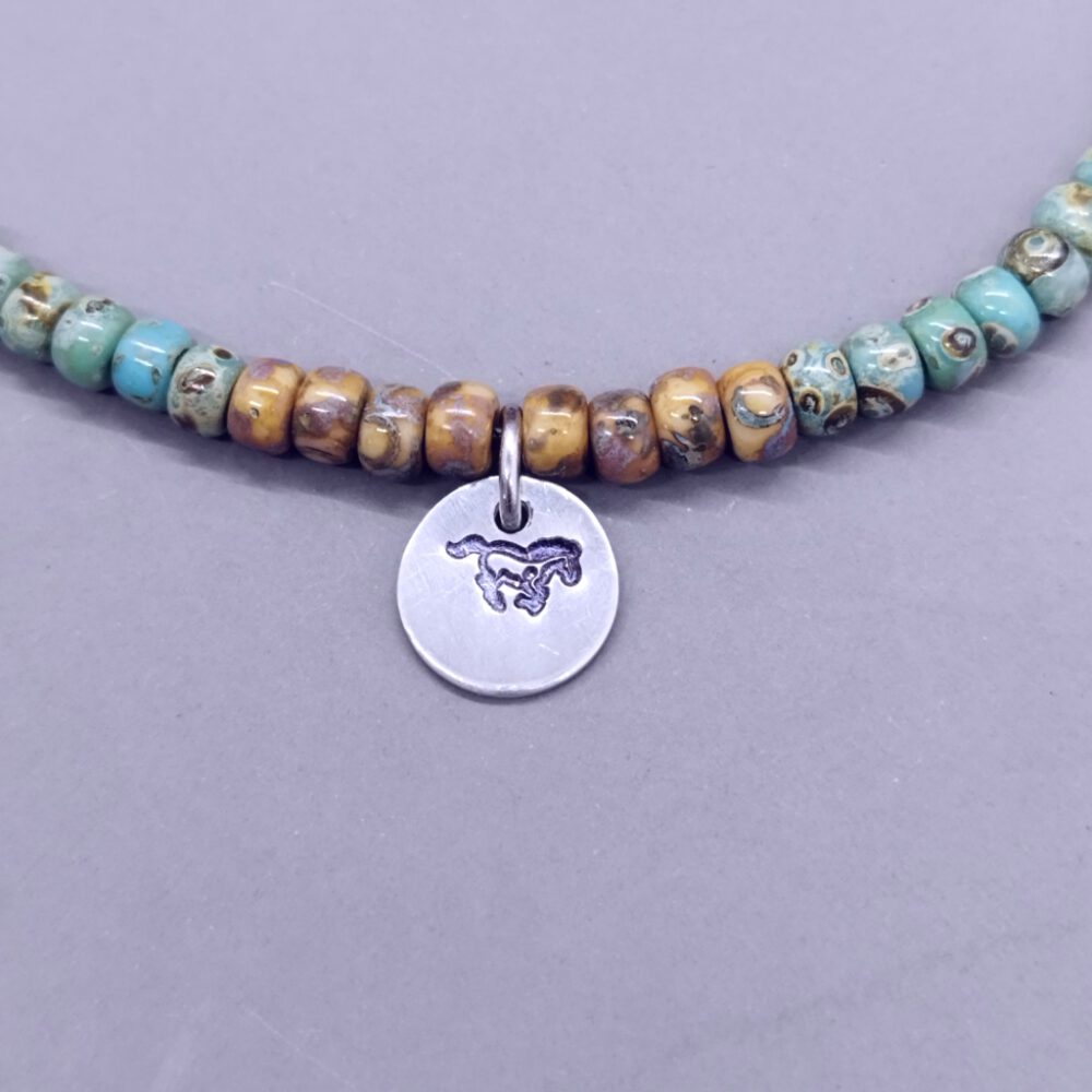 detailansicht-pferde-anhänger-auf-braunem-armband Miyuki Perlen Armband Anhänger Pferd