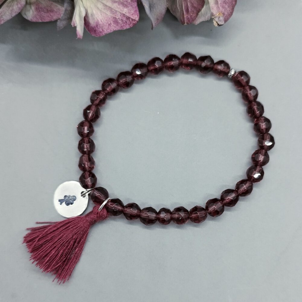 Die zarte, farblich passende Quaste verleiht dem Armband eine besondere Note. Armband weinrote Kristalle, elastisch