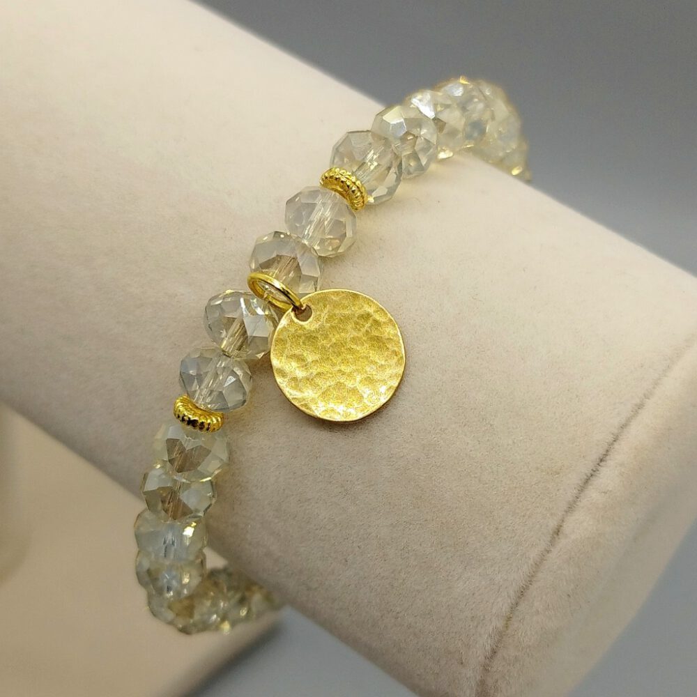 Detailaufnahme der funkelnden Kristalle und der Struktur des Messing-Anhängers. Armband Kristalle gold Messing-Anhänger