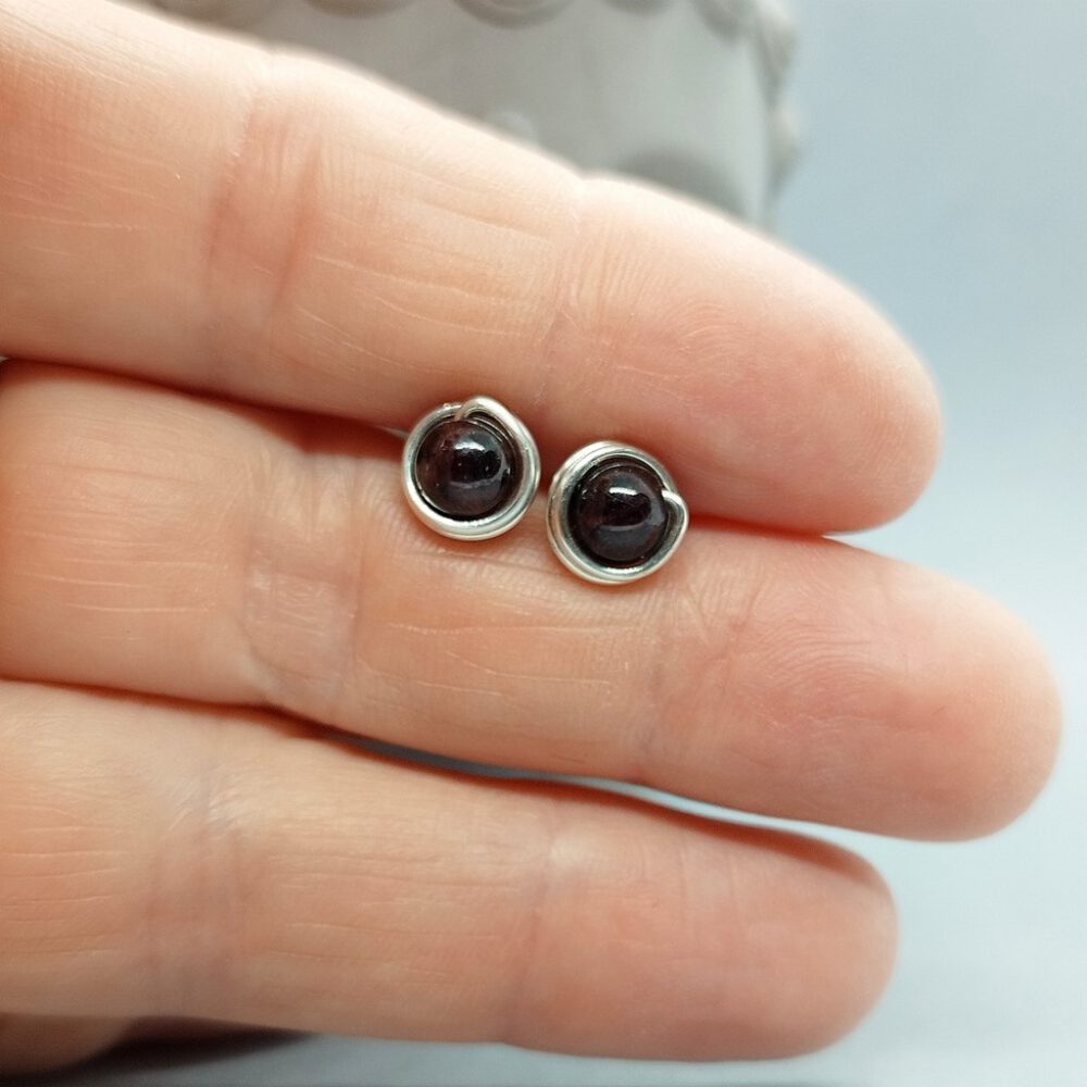 Nahaufnahme der tiefroten Granatperlen im minimalistischen Design. Ohrstecker Granat 935 Silber