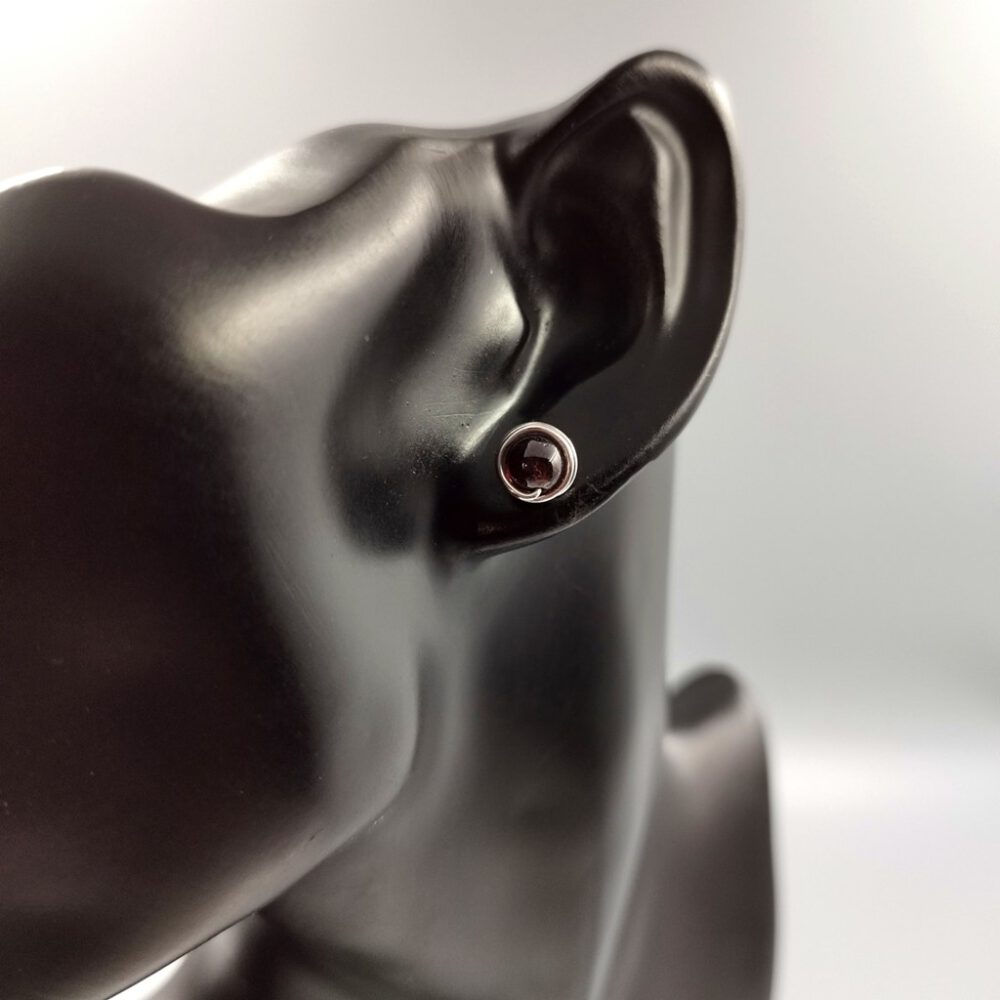 Ohrstecker getragen an einem Ohrmodel für Größenvergleich. Ohrstecker Granat 935 Silber
