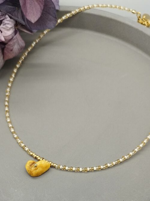 Zarte Choker-Kette aus weißen und goldenen Rocailles mit milchigem Bernsteinanhänger. Kette weiß gold mit Bernstein Anhänger