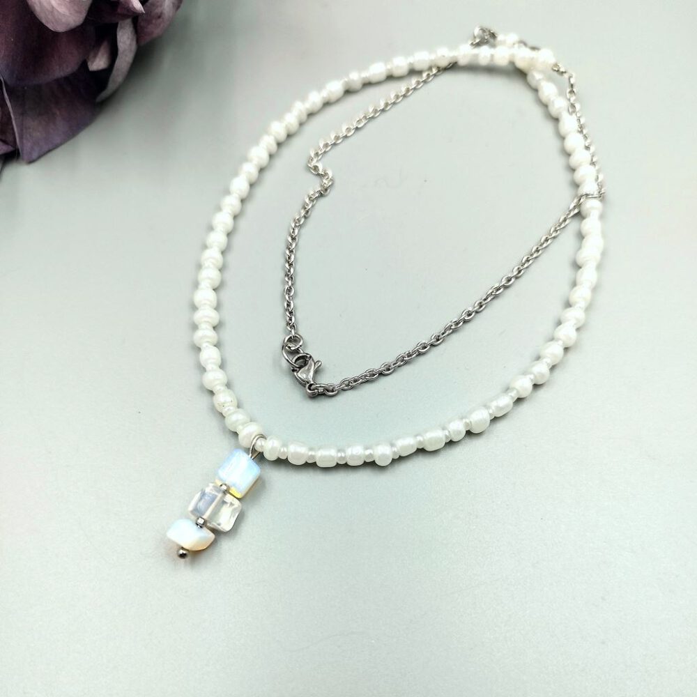Nahaufnahme der weißen Rocailles mit Edelstahl-Kette Kette weiß-silber mit Milchopalsplitter