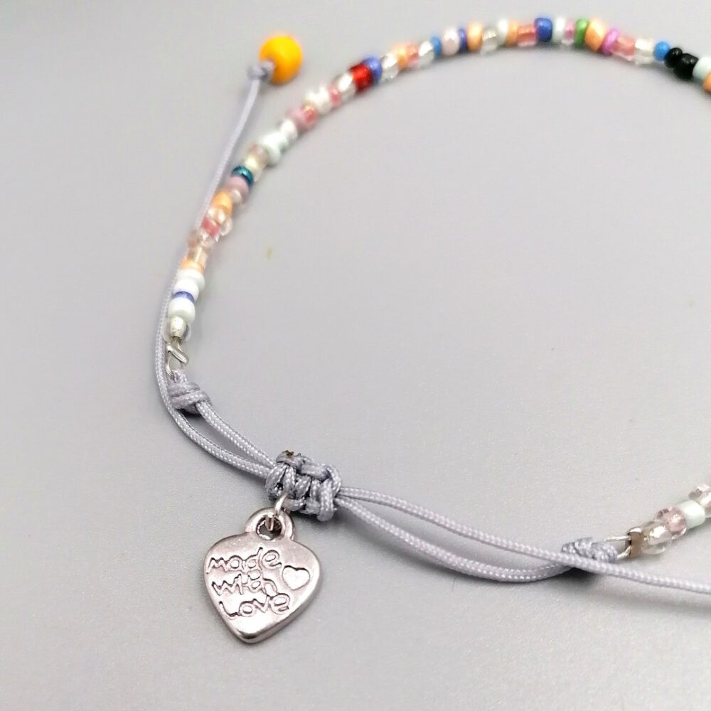 Detailaufnahme Herzanhänger am bunten Rocaille-Armband Buntes Boho Armband mit Herzanhänger