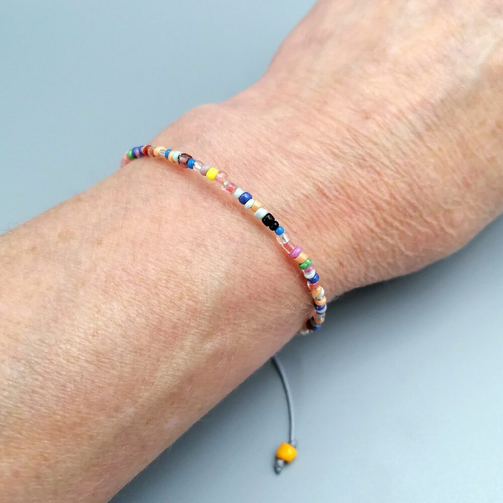 Sommerliches Boho Armband auf Handgelenk getragen Buntes Boho Armband mit Herzanhänger