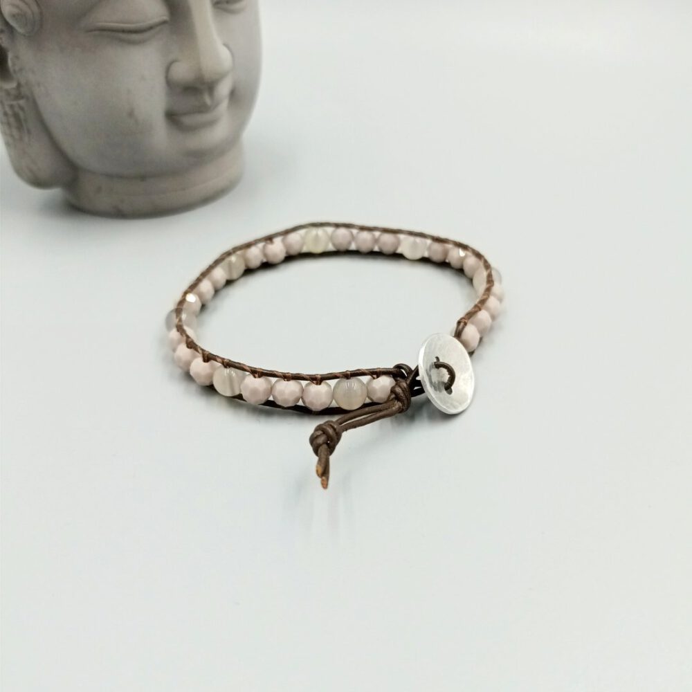 Boho-Armband aus Leder mit gehämmertem silberfarbenem Verschluss-Knopf auf hellem Hintergrund. Leder Armband braun mit Kristall & Achat