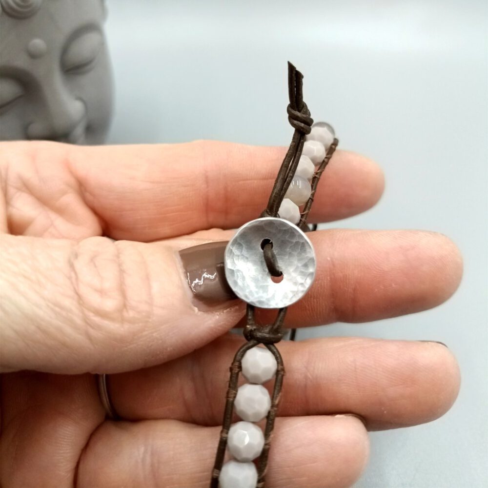 Der handgefertigte Silberknopf-Verschluss aus gehämmertem Metall im Fokus. Leder Armband braun mit Kristall & Achat