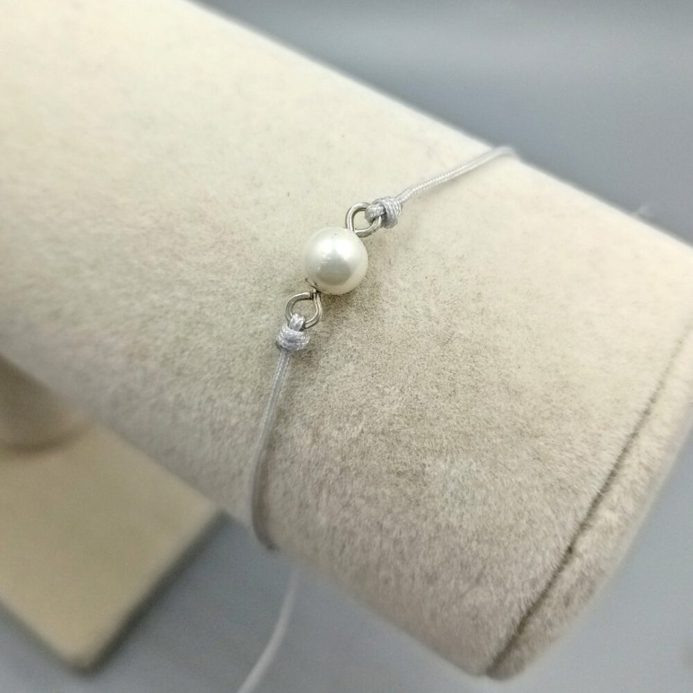 Detailaufnahme der eingefassten Muschelkernperle Textilarmband mit weißer Muschelkernperle