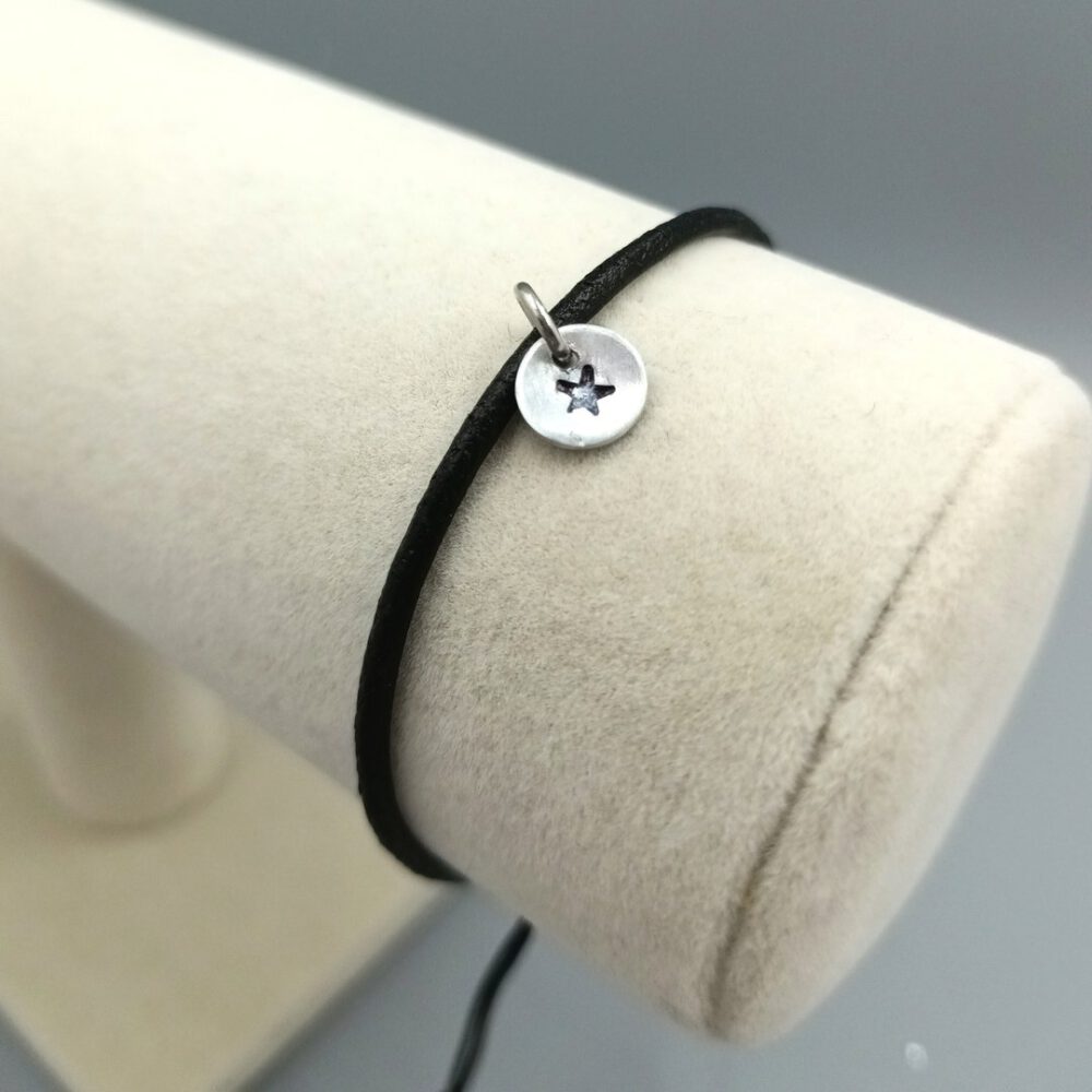 Detailaufnahme des handgestempelten Sterns auf der Metallscheibe Lederarmband schwarz mit Stern Anhänger