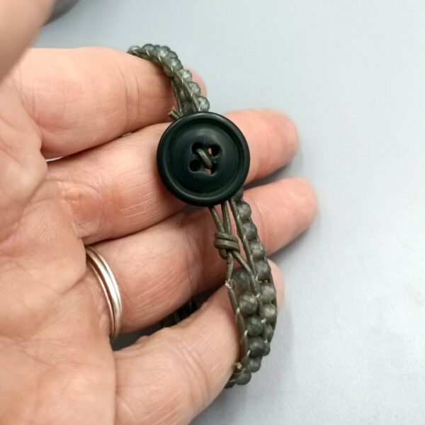 Nahaufnahme der handvernähten Perlen Wickelarmband olivgrün mit Kristallperlen