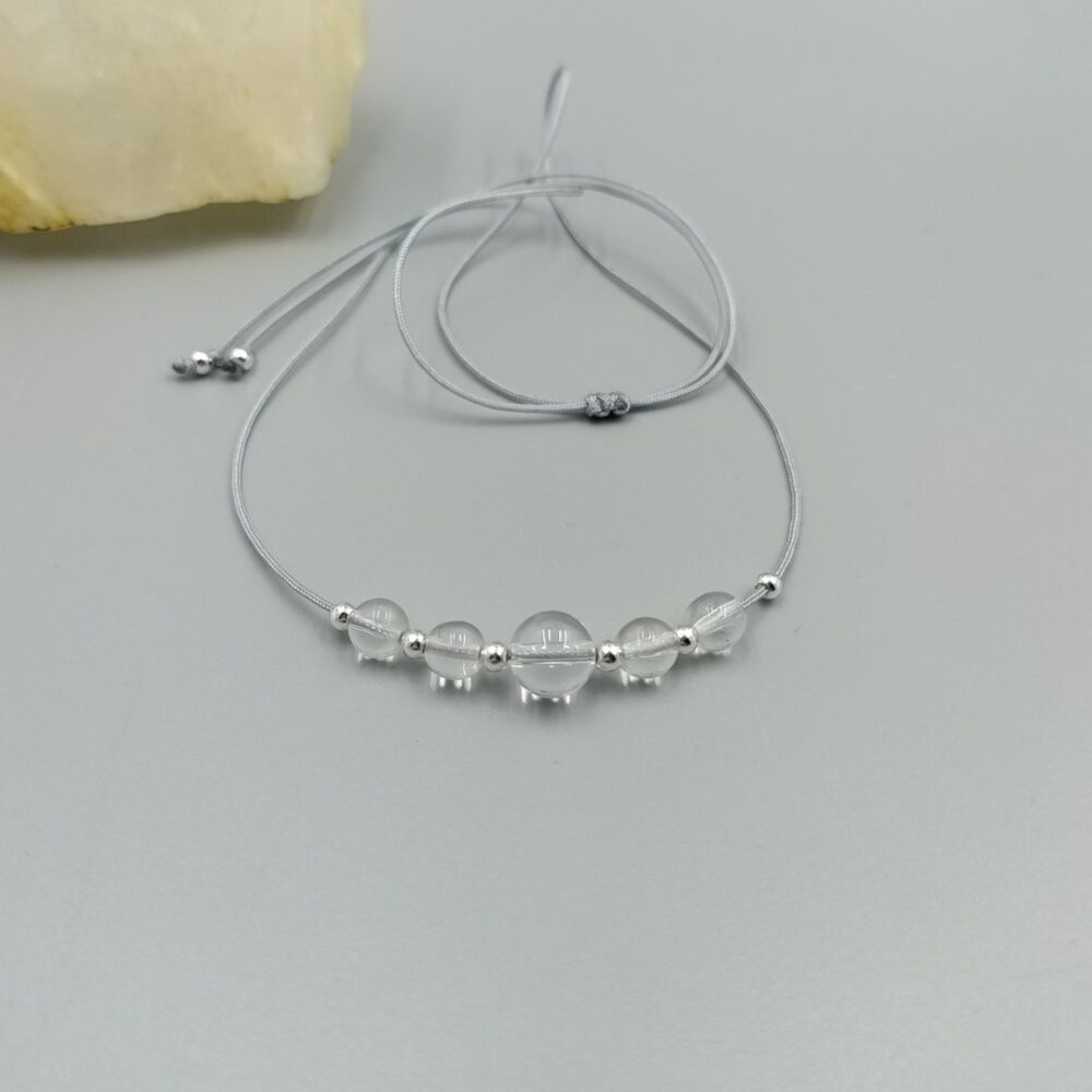 Bergkristall Kette auf neutralem Hintergrund drapiert Zarte Bergkristall Kette mit Edelstahlperlen