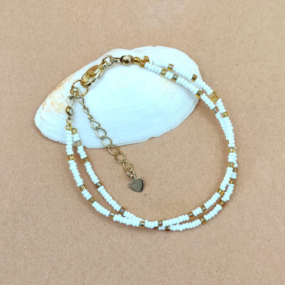 Seitenansicht der doppelten Perlenstränge des mattweißen Rocailles-Armbands Zweireihiges Armband Weiß-Gold mit Herz